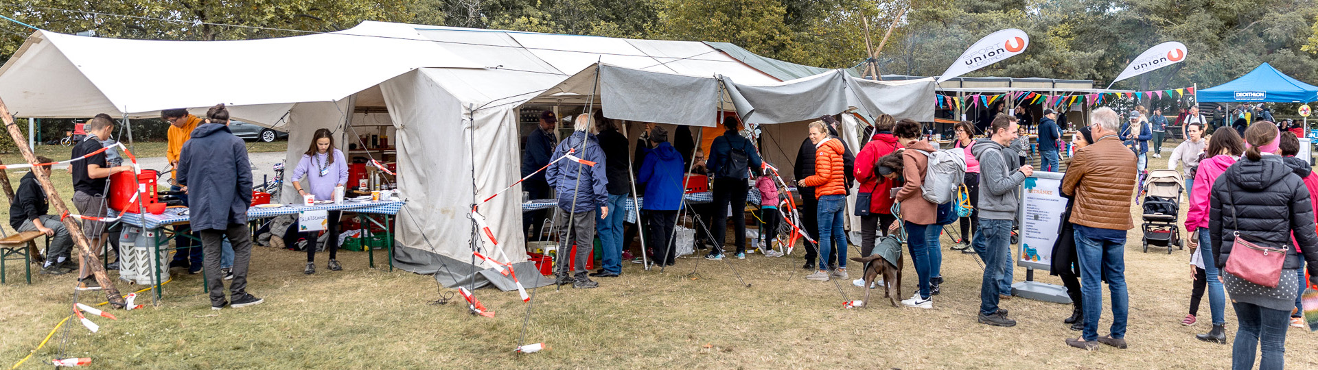 Menschenschlange steht bei den Pfadizelten fuer Essensausgabe an